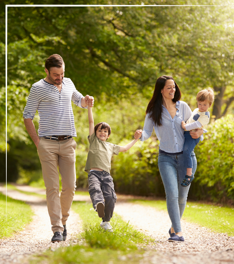 Family walking down a path together, happy and holding hands, symbolizing the family harmony successful Pathways behavior coaching creates